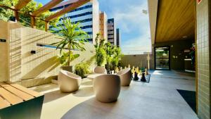 a balcony with a bunch of chairs on a building at Studio Desing 3 - Lions Maceió in Maceió