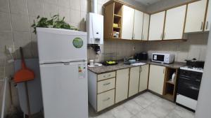 a kitchen with a white refrigerator and a microwave at Departamento La Merced in Santiago del Estero