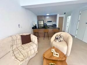 a living room with a couch and chairs and a table at Downtown Chic Donde inicia la diversión en Punta Cana in Punta Cana