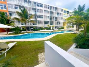 a swimming pool in front of a large building at Downtown Chic Donde inicia la diversión en Punta Cana in Punta Cana