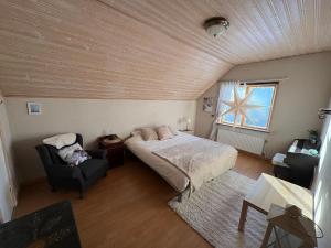 a bedroom with a bed and a chair at Boreal Cottage in Karungi