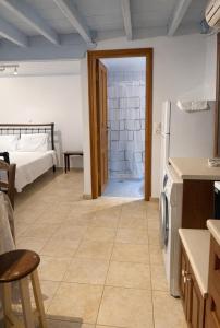 a kitchen with a refrigerator and a bedroom with a bed at Aegean soul apartments in Halki
