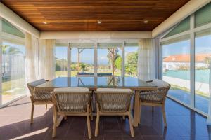 a dining room with a glass table and chairs at Casa da Colina, By Home Match in Sesimbra