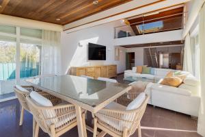 a dining room with a glass table and chairs at Casa da Colina, By Home Match in Sesimbra