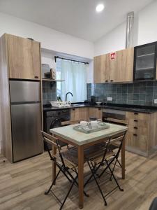 a kitchen with a table and a stainless steel refrigerator at Casinhas da Ajuda nº13 in Lisbon +24 photos