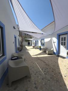 a row of white chairs in a building with an archway at Casinhas da Ajuda nº13 in Lisbon