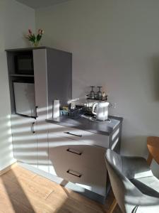 a kitchen with a refrigerator and a table and a chair at Mieszkanko w centrum in Lidzbark Warmiński +7 photos