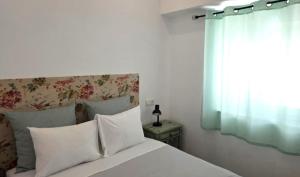 a bedroom with a white bed with a window at Casinhas da Ajuda nº13 in Lisbon