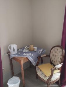 a small table with a chair and a table with a tea set at Le Kalblin in Fréland +14 photos