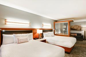 a hotel room with two beds and a mirror at SpringHill Suites Denver at Anschutz Medical Campus in Aurora