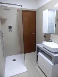 a bathroom with a glass shower and a sink at Casa Marta - tra vigne e motori in Castelvetro di Modena +32 photos
