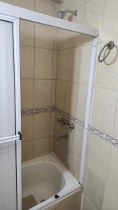 a bathroom with a shower with a white tub at Departamento La Merced in Santiago del Estero +8 photos