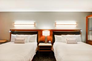two beds in a hotel room with white sheets at SpringHill Suites Denver at Anschutz Medical Campus in Aurora