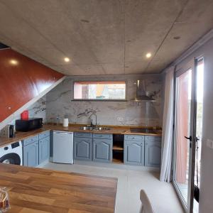a kitchen with blue cabinets and a sink at Casas do Pargo - Casa B Palheiro in Ponta do Pargo