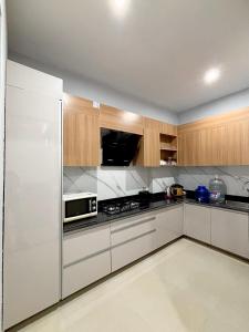 a kitchen with wooden cabinets and a stainless steel refrigerator at Sukoonat Gah in Srinagar +7 photos