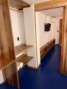 a room with wooden shelves and a tv on a wall at Aloha.ayampe in Ayampe