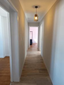 a hallway with white walls and wood floors at Le Refuge de la Tour in Calais