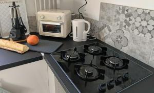 a kitchen counter with a stove and a toaster oven at Le Refuge de la Tour in Calais +17 photos