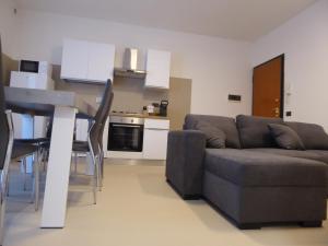 a living room with a couch and a table and a kitchen at Casa Marta - tra vigne e motori in Castelvetro di Modena