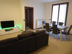 a living room with a couch and a table with chairs at Casa Marta - tra vigne e motori in Castelvetro di Modena
