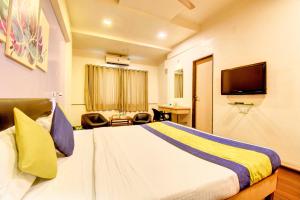 ein Hotelzimmer mit Bett und Fernseher in der Unterkunft MY Bizz Hotel Sapna in Pune