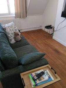 a teddy bear sitting on a couch with a coffee table at Le Refuge de la Tour in Calais