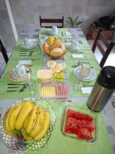 a table with bananas and fruit on a green table cloth at Will's House Residência Familiar in São Luís +15 photos