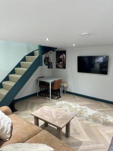 a living room with a staircase and a table at Holly studio in Midhurst