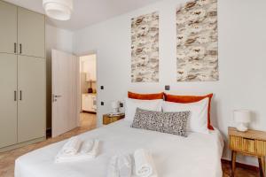 a bedroom with a white bed with two slippers on it at VERSA by Apiro Syros in Ermoupoli