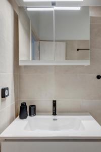 a bathroom with a sink and a mirror at VERSA by Apiro Syros in Ermoupoli +11 photos