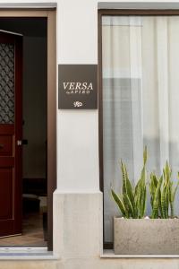 a window with a plant in a pot next to a door at VERSA by Apiro Syros in Ermoupoli