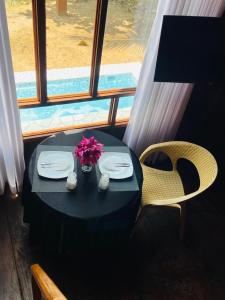 a black table with plates and flowers and a window at Gimanhala Thisawewa in Anuradhapura