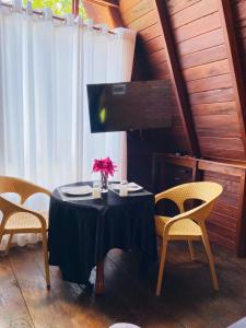 a table with chairs and a vase of flowers on it at Gimanhala Thisawewa in Anuradhapura