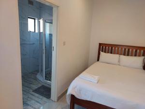 a small bedroom with a bed and a shower at Kafusi Lodge in Victoria Falls +13 photos