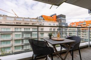 a balcony with a table and chairs and a city at Casiola - Spacious & light apartment with double terrace in Nieuwpoort