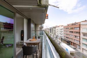 a balcony with a table and a view of a city at Casiola - Spacious & light apartment with double terrace in Nieuwpoort