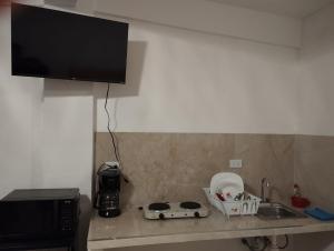 a kitchen counter with a sink and a microwave at Lofts en el Corazon de Coatepec Veracruz in Coatepec