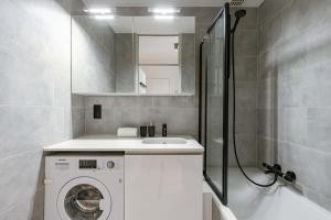 a bathroom with a washing machine and a shower at Casiola - Nice apartment close to the beach with parking in Nieuwpoort +16 photos