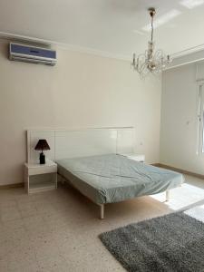 a white bedroom with a bed and a chandelier at Villa Horizon & Pool Bizerte in Bizerte +30 photos