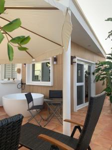 a patio with a tub and chairs and an umbrella at Las Arenas in Costa Calma