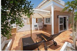 a patio with an umbrella and a table and chairs at Las Arenas in Costa Calma