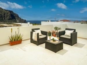 two chairs and a table on a balcony with plants at Sunset Terrace Studio - Ocean View - Top Floor in Buenavista del Norte +33 photos