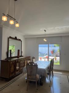 a dining room with a table and chairs and a mirror at Villa Horizon & Pool Bizerte in Bizerte