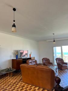 a living room with leather chairs and a couch at Villa Horizon & Pool Bizerte in Bizerte