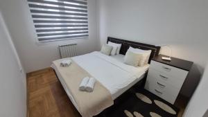 a bedroom with a bed with two towels on it at Apartman Dreams Lukavica in Lukavica