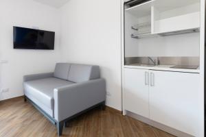 a white couch in a room with a kitchen at L'Ariana Resort, Glamping in Rinella