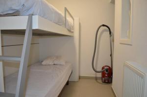 a small room with a bunk bed and a fire extinguisher at Cozy Apartment for 4 Steps from the Beach in Ostend