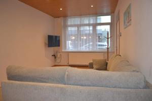 a couch in a living room with a window at Cozy Apartment for 4 Steps from the Beach in Ostend