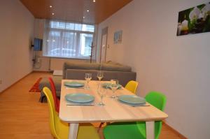 a wooden table with chairs and wine glasses on it at Cozy Apartment for 4 Steps from the Beach in Ostend