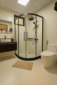 a bathroom with a shower and a toilet and a sink at Sonasea Vân Đồn - Centraltique Seaside in Quang Ninh +13 photos